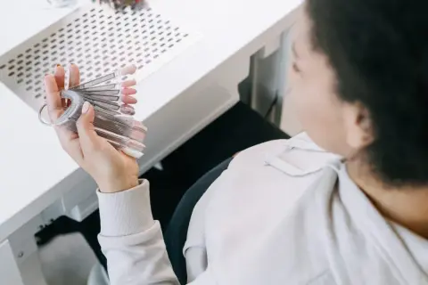 En gravid kvinna väljer nagellack från en provkollektion.
