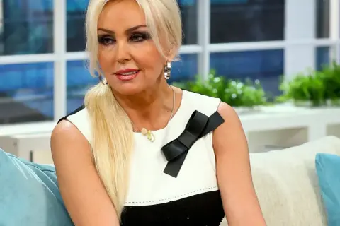 Justyna Łuszcz, żona Magika, w czarno-białej sukience z kokardą.