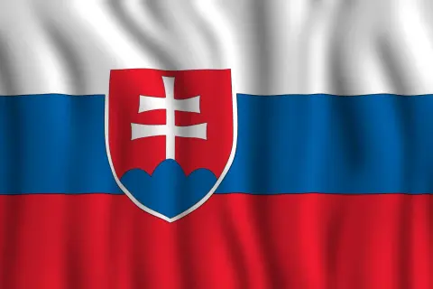 Flaga Słowacji powiewa na wietrze. Biało-niebiesko-czerwone pasy z godłem Słowacji, przedstawiającym podwójny krzyż na trzech wzgórzach.
