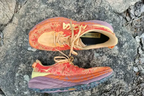 Kolorowe buty Hoka Speedgoat 6 na kamieniu. Hoka to firma znana z amortyzacji i komfortu.