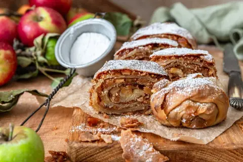 Pyszne ciasto z jabłek, posypane cukrem pudrem, pokazuje, co można zrobić z jabłek. Idealne na deser.