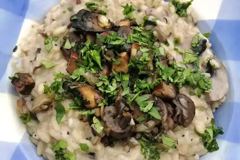 Delicioso risotto de setas cremoso, coronado con champiñones salteados y perejil fresco picado.