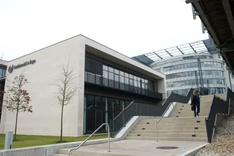 Moderne Architektur der FernUni in Hagen, NRW. Eine Person steigt eine breite Treppe hinauf.