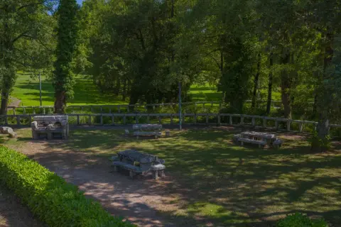 Área recreativa con mesas de piedra y barbacoa, un lugar idílico cerca del nacimiento del Miño.