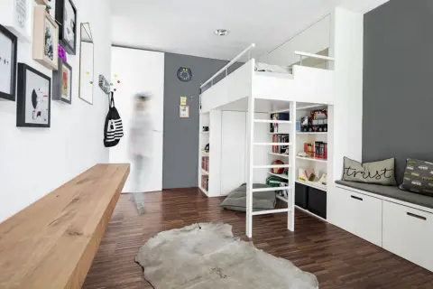 Cleverer Stauraum im Kinderzimmer: Hochbett mit integrierten Regalen und Schränken, DIY-Bank und Wandhaken für Ordnung.