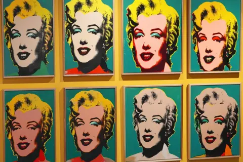 Osiem portretów Marilyn Monroe w stylu pop art Warhol, każdy z innym kolorystycznym wyrazem ikony.