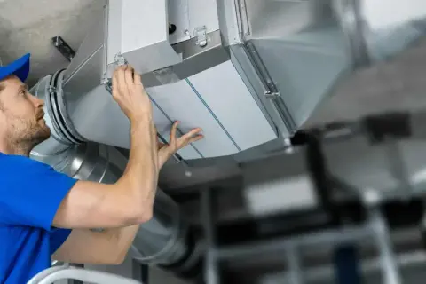 Installatör byter filterduk i ventilationssystem. Ren luft är viktigt för hälsan.