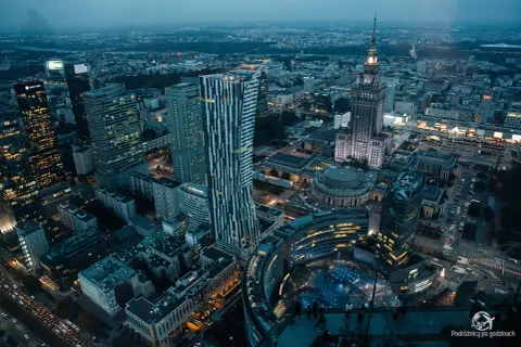 Widok z góry na nocną panoramę Warszawy, z wieżowcami i Pałacem Kultury. Marzysz o takich widokach? Kup bilety na Varso Tower!