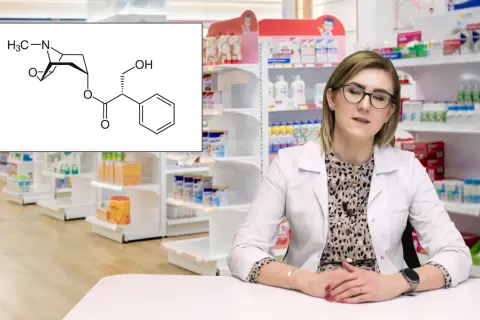 Schemat cząsteczki scopolanu, leku stosowanego m.in. w chorobie lokomocyjnej, obok farmaceutki w aptece.