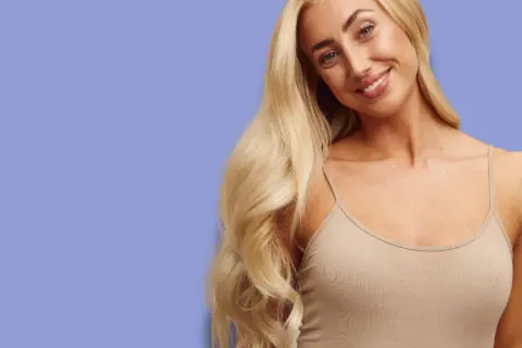 Uśmiechnięta blondynka z bujnymi, falowanymi włosami. Zastanawiasz się, jak szybko rosną włosy? Ona wie!