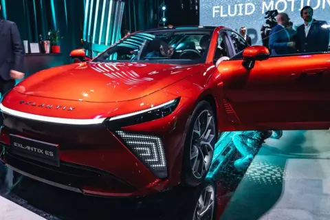 Błyszczący, czerwony Exlantix ES z otwartymi drzwiami, prezentowany na targach. Futurystyczny design i innowacyjne oświetlenie.