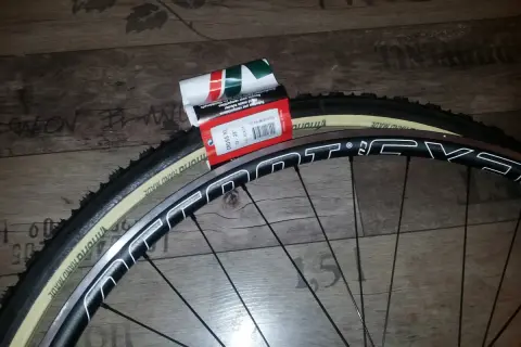 Nowa szytka rowerowa Vittoria Cross XL 33-28" czeka na założenie na obręcz koła.