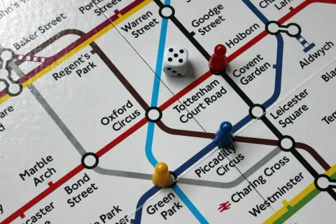 Planszówka pociągi: pionki i kostka na mapie londyńskiego metra.