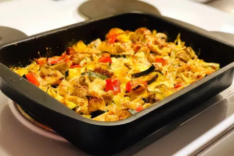 Enkel kycklinggratäng med grönsaker och smält ost i en ugnsform. Ett perfekt kyckling recept enkelt för middagen.