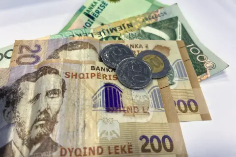 Banknoty i monety, które pokazują, jaka waluta w Albanii. Widoczne są nominały 20, 200 i 1000 leków.