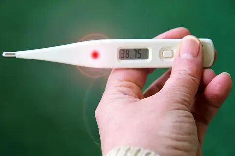 Cyfrowy termometr pokazuje 38.75. Podwyższona temperatura w ciąży wymaga konsultacji z lekarzem.