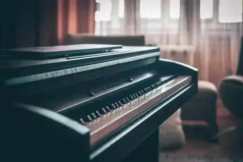 Ciemne pianino cyfrowe z klawiaturą w zbliżeniu. Zastanawiasz się, ile waży pianino? Ten instrument jest solidny.