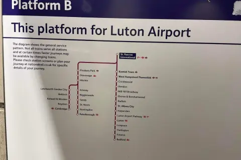 Tablica "Platform B" informuje, że ten peron jest dla pociągów do Luton Airport. Mapa pokazuje trasę z Londynu do Luton.