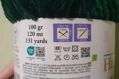 Etykieta z informacjami o różnych rodzajach włóczek: 100g, 120m, 131 jardów. Wskazówki dotyczące rozmiaru drutów i oczek. Certyfikat OEKO-TEX®.