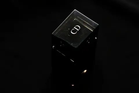 Czarny, szklany flakonik perfum z logo "CD". Czy perfumy mają datę ważności? Ten flakonik wygląda na wieczny.