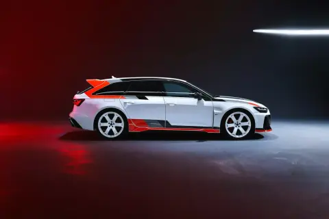 Białe Audi RS6 GT z pomarańczowymi akcentami i czarnymi pasami, gotowe do wyścigu.