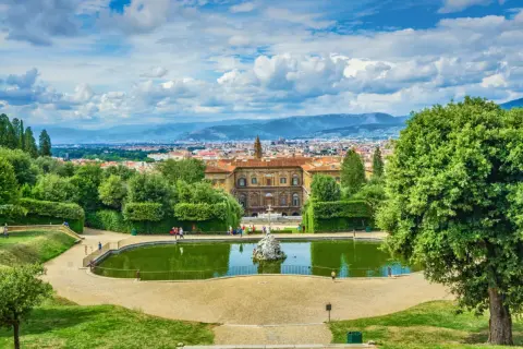 Vista panoramica dei Giardini di Boboli con stagno, palazzo e Firenze sullo sfondo.