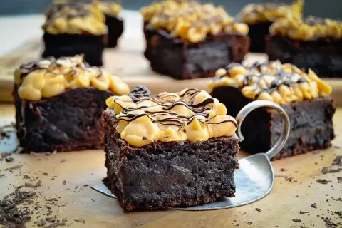 Saftige schoko brownies mit cremiger Topping und Schokodrizzle, verlockend dekoriert mit Schokostreuseln.
