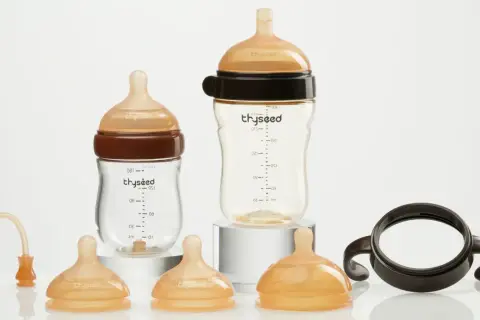 Two baby bottles and accessories. Consider how often to replace plastic baby bottles for safety.