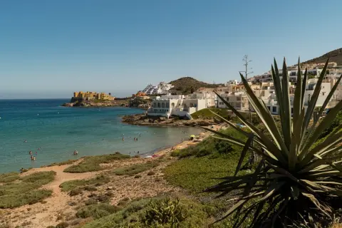 Costa de San José con casas blancas, playa y mar turquesa. Ideal para ver qué ver en San José y disfrutar del sol.