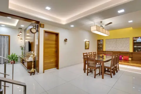 A modern dining room with a wooden table and chairs, featuring a sleek tile placement on the floor.