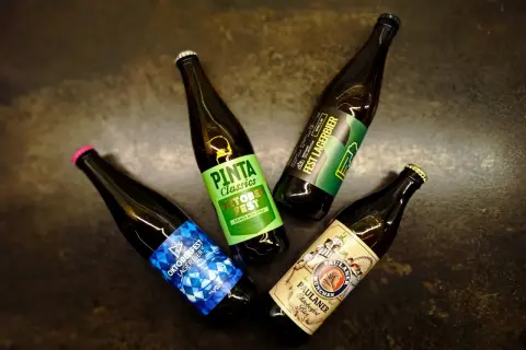 Cztery butelki piwa, w tym niemieckie piwo Paulaner Oktoberfest.