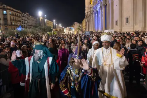 La cabalgata Miralbueno ilumina la noche con los Reyes Magos saludando a la multitud.