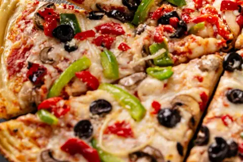 Pyszna pizza z serka wiejskiego, z pieczarkami, papryką i oliwkami. Idealna na szybki obiad.