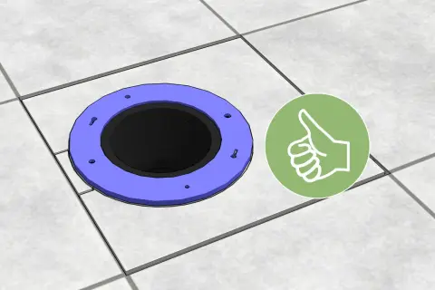 A toilet flange sits on tiled flooring, showing how to cut tile around toilet for a perfect fit. A green thumbs-up icon indicates success.