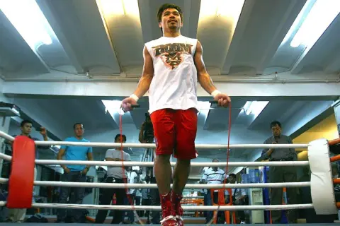 Boxers jump rope to build stamina and footwork. Manny Pacquiao trains in a boxing ring, surrounded by spectators.