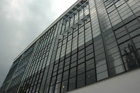 Szklana fasada budynku, przykład modernizmu. Charakterystyczne okna wychylne tworzą ciekawy wzór.
