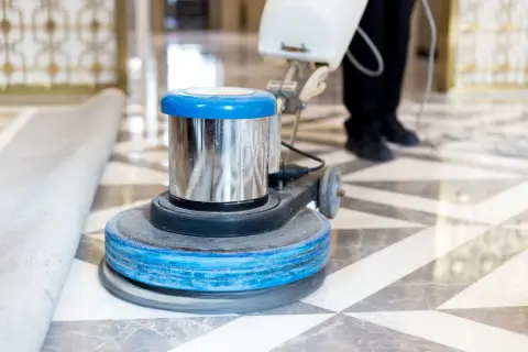 Macchina lucidatrice in azione su un pavimento in marmo. Un professionista sta lavorando per capire come pulire il marmo vecchio, riportandolo al suo antico splendore.