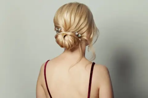Eleganckie, luźne upięcia włosów do ramion z błyszczącymi spinkami. Delikatne pasma opadają na ramiona, tworząc romantyczny look.