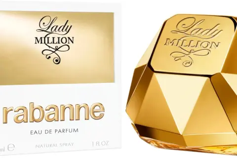 Złoty flakon perfum Lady Million od Rabanne, przypominający diament, obok białego pudełka z napisem "one milon".
