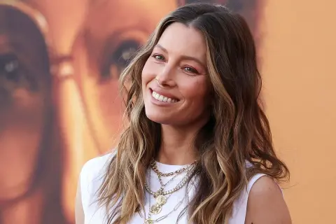 Jessica Biel sonríe con su pelo liso y mechas balayage, luciendo un collar de varias cadenas.
