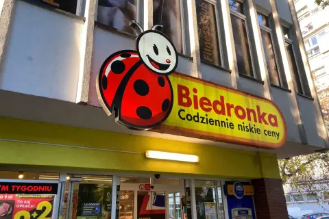 Logo Biedronki i szyld sklepu. Zastanawiasz się, jak odebrać wygraną ze zdrapki Biedronka? Sprawdź w sklepie!