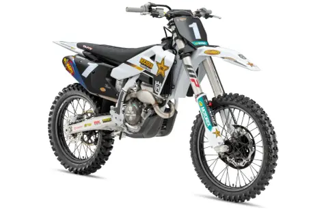 Biały motocykl Husqvarna 250 cross z numerem 1 na tablicy, ozdobiony logotypami Rockstar Energy i Motorex.