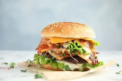 Apetyczny burger z bekonem, serem i warzywami. Zastanawiasz się nad big mac kcal? Ten burger wygląda na sycący!