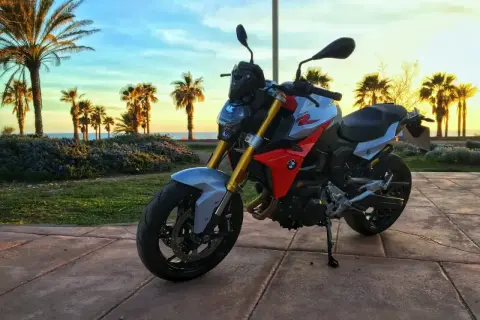 BMW F 900 R na tle palem i zachodzącego słońca nad morzem. Idealny motocykl na wakacyjne podróże.
