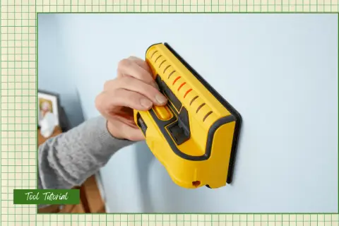 Learn how to use a stud finder to locate wall studs for secure mounting. This yellow tool is pressed against the wall.