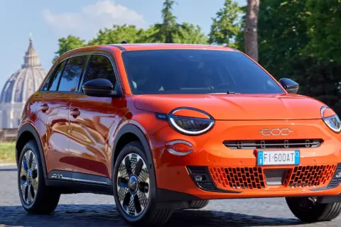 Pomarańczowy Fiat 600 na tle rzymskiej kopuły. Sprawdź atrakcyjną fiat 600 cena!