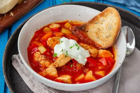 En värmande kyckling soppa med paprika, potatis och en klick gräddfil. Serveras med rostat bröd.