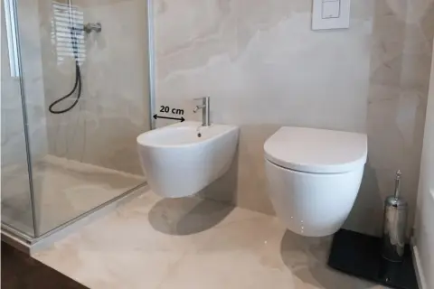 Bagno moderno con bidet e WC sospesi. Misura 20 cm tra i sanitari per un'installazione ottimale.