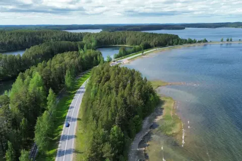Malownicze jeziora i lasy Finlandii. Droga wije się wśród zieleni, idealna na podróż, by odkryć, co zobaczyć w Finlandii.