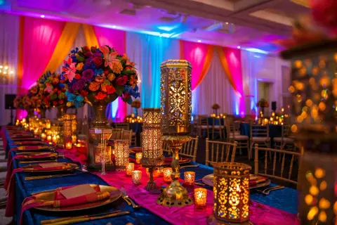 Décoration d'inspiration Bollywood, lanternes ajourées, bougies scintillantes et fleurs éclatantes sur une table dressée. Une ambiance féerique à faire soi-même.
